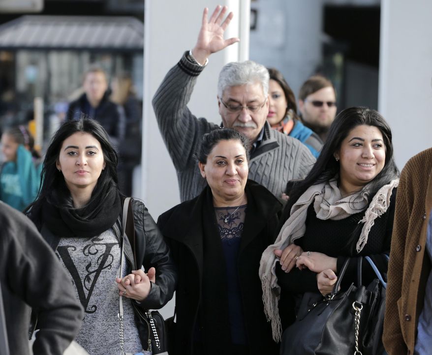 Iman Alknfushe, center, exits John F. Kennedy International airport with her daughters Elaf, right, and Anfal Hussain in New York, Sunday, Jan. 29, 2017. Attorneys advocating on her behalf said Alknfushe was coming from Iraq and had been detained at the airport for more than 30 hours. President Donald Trump's immigration order sowed more chaos and outrage across the country Sunday, with travelers detained at airports, panicked families searching for relatives and protesters registering opposition to the sweeping measure that was blocked by several federal courts.(AP Photo/Seth Wenig)