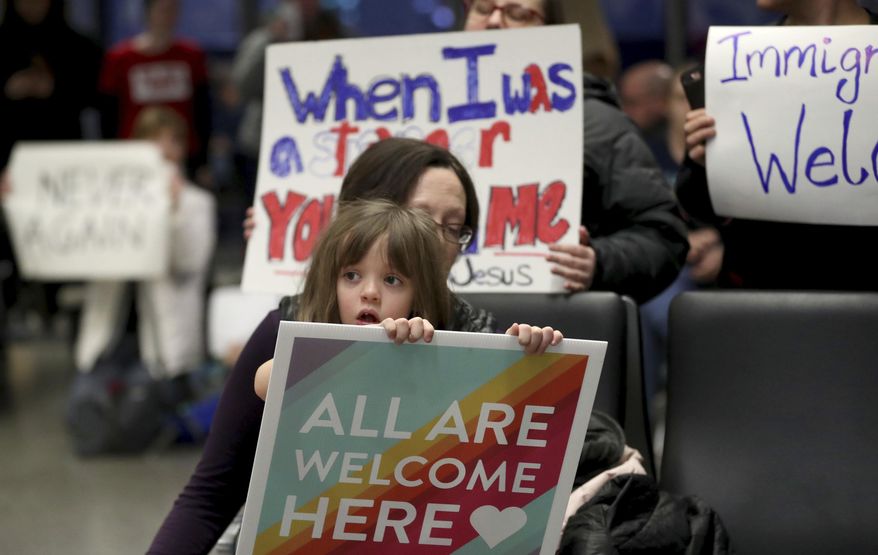 Rachel Walker, center, of St. Paul and her daughter Evelyn, 7, front, join others in protesting an executive order signed by President Donald Trump restricting immigration from several Muslim nations Saturday, Jan. 28, 2017, at the Minneapolis-St. Paul International Airport, in Minneapolis. (David Joles/Star Tribune via AP)