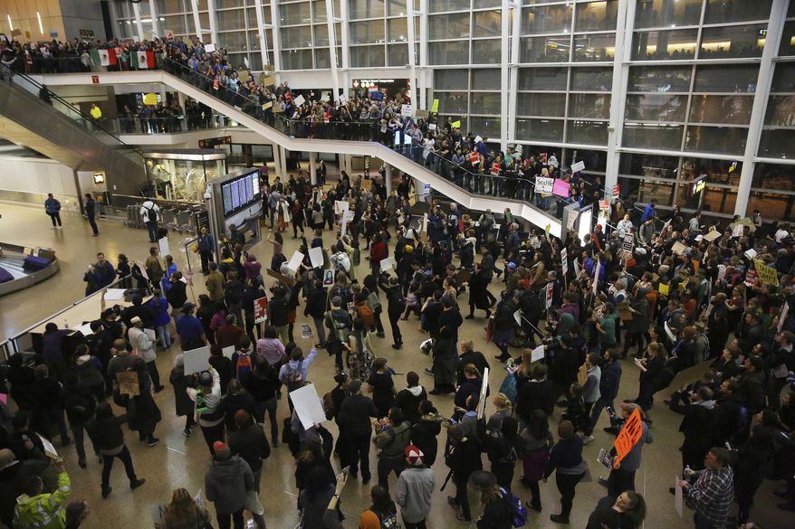 More than 1,000 people gather at Seattle-Tacoma International Airport, to protest President Donald Trump's order that restricts immigration to the U.S., Saturday, Jan. 28, 2017, in Seattle. President Trump signed an executive order Friday that bans legal U.S. residents and visa-holders from seven Muslim-majority nations from entering the U.S. for 90 days and puts an indefinite hold on a program resettling Syrian refugees. (Genna Martin/seattlepi.com via AP)