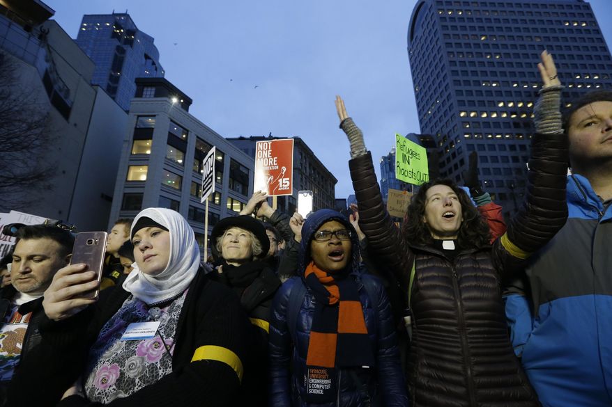 Protesters take part in a rally to oppose President Donald Trump's travel ban on refugees and citizens of seven Muslim-majority nations, Sunday, Jan. 29, 2017, in downtown Seattle. (AP Photo/Elaine Thompson)