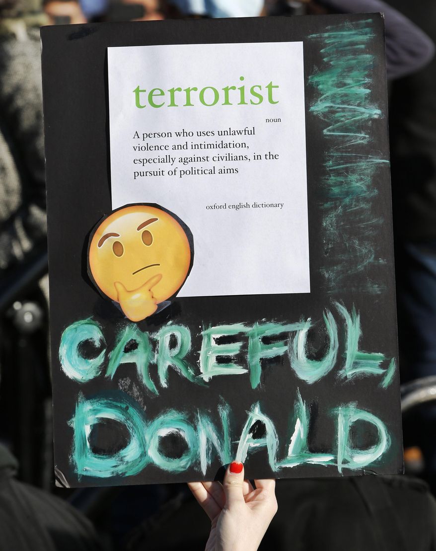 A woman holds up a sign with the definition of the word terrorist on it as she and others participate in an immigrants' rights' rally Sunday, Jan. 29, 2017, in New York's Battery Park. President Donald Trump's immigration order sowed more chaos and outrage across the country Sunday, with travelers detained at airports, panicked families searching for relatives while protesters registered opposition to the sweeping measure that was blocked by several federal courts. (AP Photo/Kathy Willens)