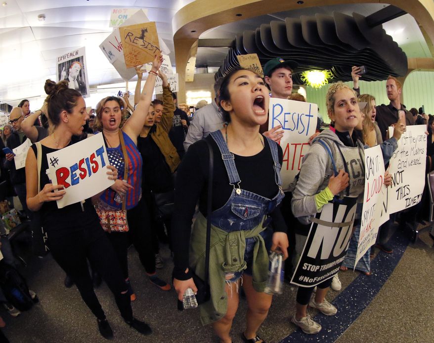 Demonstrators chant inside Tom Bradley International Terminal as protests against President Donald Trump's executive order banning travel from seven Muslim-majority countries continue at Los Angeles International Airport Sunday, Jan. 29, 2017. (AP Photo/Ryan Kang)