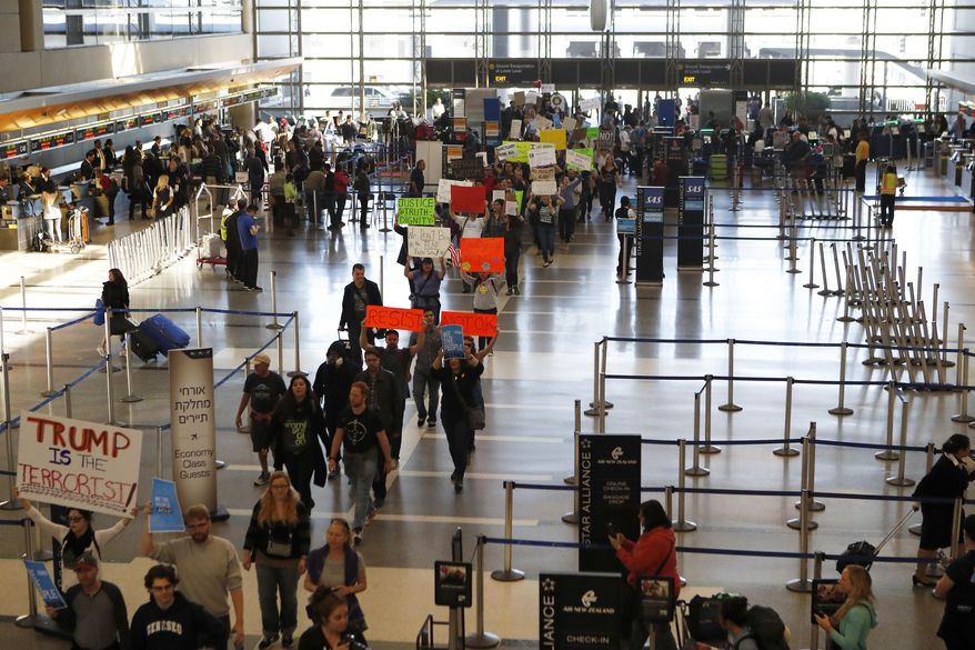 Demonstrators march through Tom Bradley International Terminal as protests against President Donald Trump's executive order banning travel from seven Muslim-majority countries continue at Los Angeles International Airport Sunday, Jan. 29, 2017. (AP Photo/Ryan Kang)