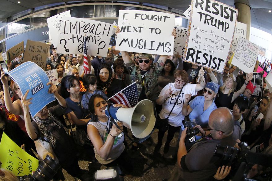 Demonstrators gather outside Tom Bradley International Terminal as protests against President Donald Trump's executive order banning travel from seven Muslim-majority countries continue at Los Angeles International Airport Sunday, Jan. 29, 2017. (AP Photo/Ryan Kang)