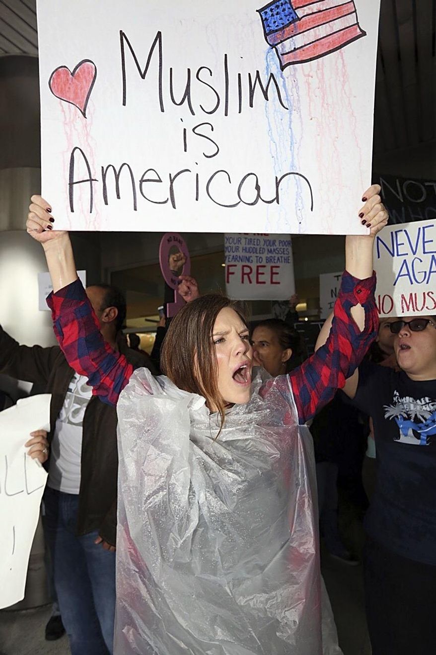 Tristan Houghton protests against President Trump's refugee ban at Miami International Airport on Sunday, Jan. 29, 2017. President Donald Trump’s immigration order sowed more confusion and outrage across the country Sunday, with travelers detained at airports, panicked families searching for relatives and protesters registering their opposition to the sweeping measure. (C.M. Guerrero/El Nuevo Herald via AP)