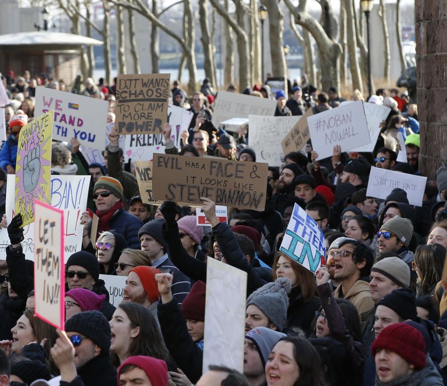 Protesters and immigrants rights advocates gather in Battery Park, Sunday, Jan. 29, 2017, in New York in opposition to President Donald Trump's most recent immigration order. Trump's immigration order sowed more chaos and outrage across the country Sunday, with travelers detained at airports, panicked families searching for relatives and protesters registering opposition to the sweeping measure that was blocked by several federal courts. (AP Photo/Kathy Willens)