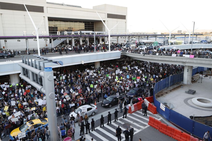 Demonstrators gather outside Tom Bradley International Terminal during a protest against President Donald Trump's travel ban on refugees and citizens of seven Muslim-majority nations, at Los Angeles International Airport on Sunday, Jan. 29, 2017. (AP Photo/Ryan Kang)