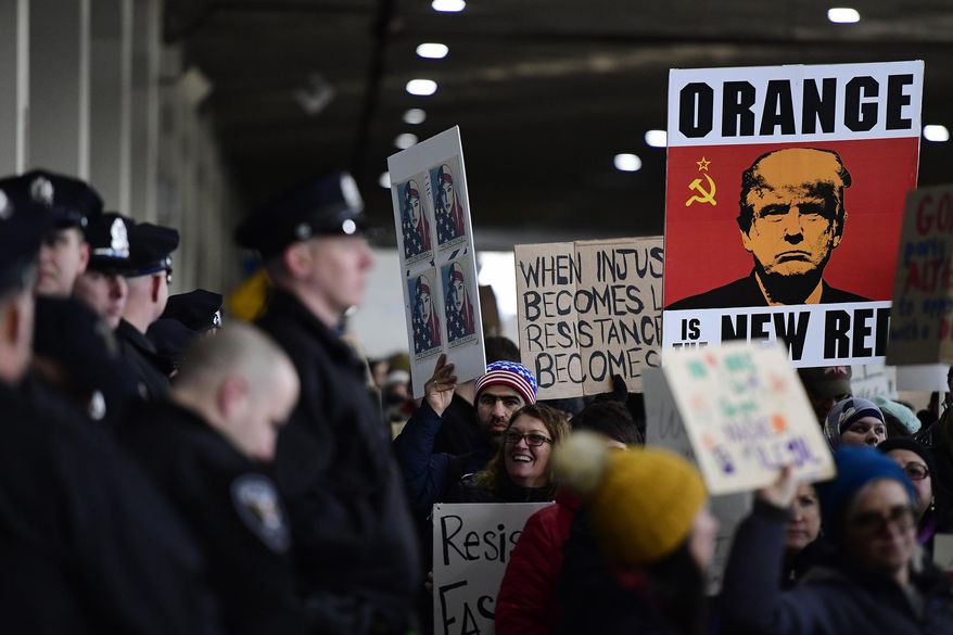 A sign reading "Orange is the New Red" is displayed in a march during a protest of President Donald Trump's travel ban on refugees and citizens of seven Muslim-majority nations, Sunday, Jan. 29, 2017, at Philadelphia International Airport in Philadelphia. (AP Photo/Corey Perrine)