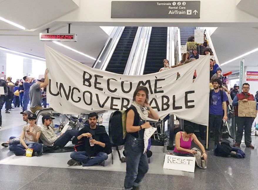 Demonstrators block an escalator at the international terminal as protests against President Donald Trump's executive order banning travel from seven Muslim-majority countries continue at San Francisco International Airport, Sunday, Jan. 29, 2017. (AP Photo/Olga Rodriguez)