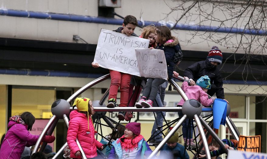 Children clamber atop a play structure before a rally protesting President Donald Trump's travel ban on refugees and citizens of seven Muslim-majority nations, Sunday, Jan. 29, 2017, in Seattle. (AP Photo/Elaine Thompson)