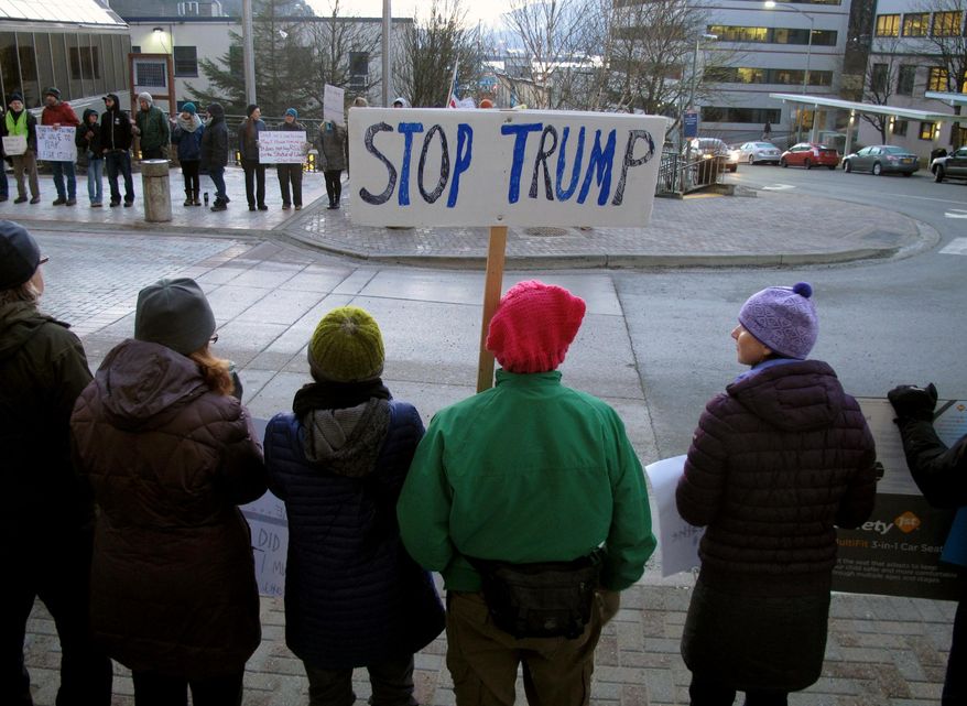 People gather in front of the Alaska Capitol on Monday, Jan. 30, 2017, in Juneau, Alaska, to protest President Donald Trump's executive order affecting immigration and refugees. (AP Photo/Becky Bohrer)