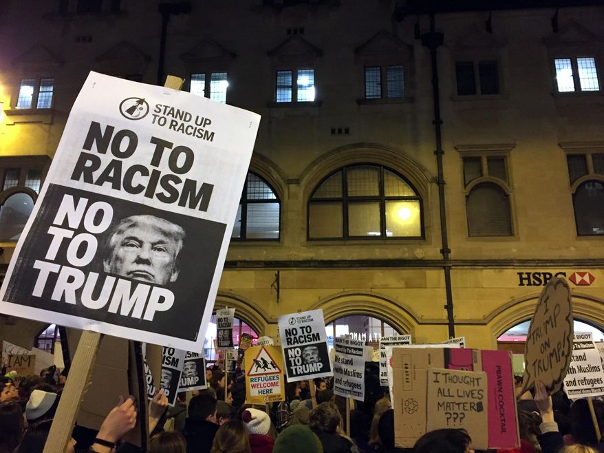 Demonstrators hold banners during a protest against U.S President Donald Trump's controversial travel ban on refugees and people from seven mainly-Muslim countries, in Oxford, England, Monday, Jan. 30, 2017. On Friday President Trump signed an executive order halting the US refugee programme for 120 days, indefinitely banning all Syrian refugees and suspended issuing visas for people from Iran, Iraq, Libya, Somalia, Sudan, Syria or Yemen for at least 90 days. (AP Photo/Sheila Norman-Culp)