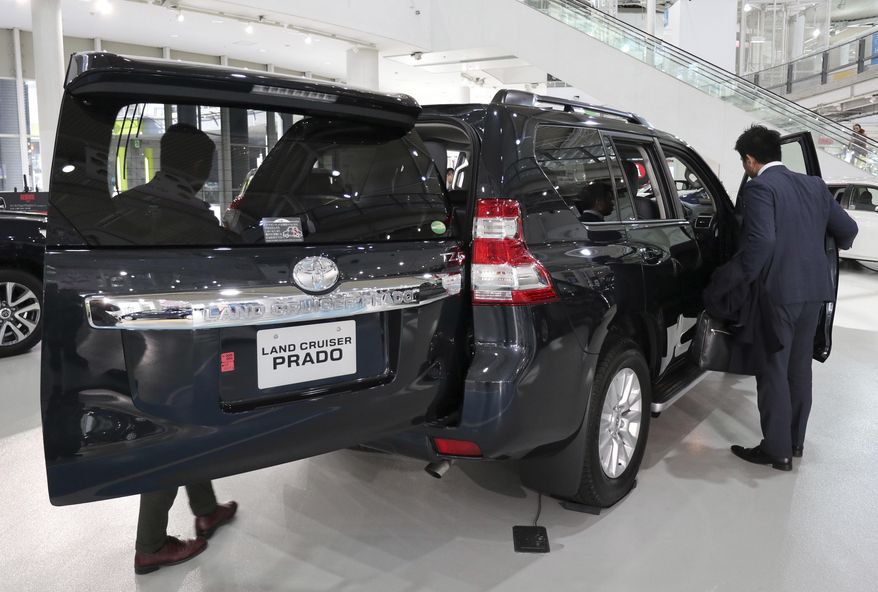 Visitors check a Toyota Land Cruser at a Toyota showroom in Tokyo, Monday, Jan. 30, 2017. Toyota has relinquished the title of the world&#39;s biggest automaker, reporting Monday that it sold 10.175 million vehicles worldwide in 2016, fewer than Volkswagen&#39;s 10.31 million. (AP Photo/Shizuo Kambayashi)
