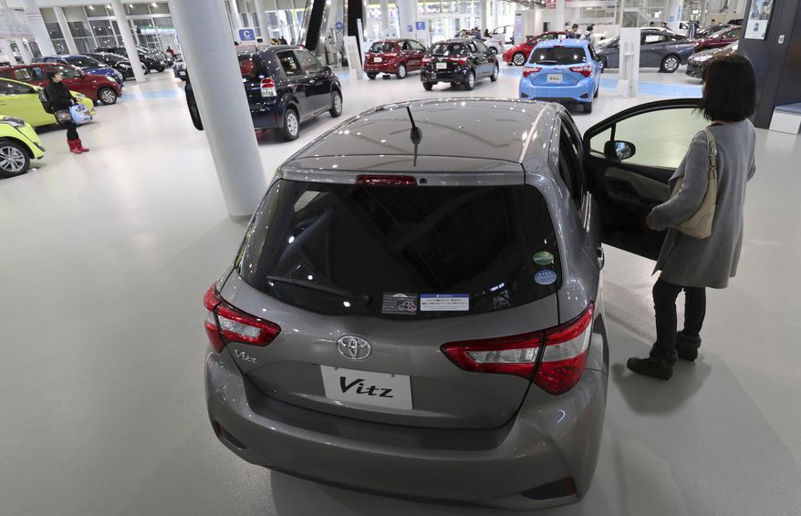 A visitor checks a Toyota Vitz hatchback subcompact car at a Toyota showroom in Tokyo, Monday, Jan. 30, 2017. Toyota has relinquished the title of the world&#39;s biggest automaker, reporting Monday that it sold 10.175 million vehicles worldwide in 2016, fewer than Volkswagen&#39;s 10.31 million. (AP Photo/Shizuo Kambayashi)