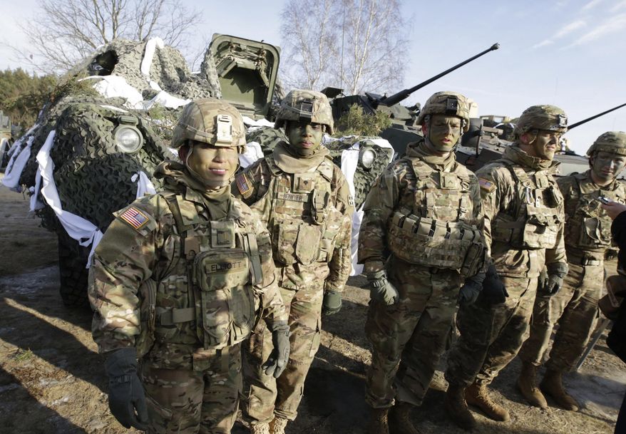 U.S. Army soldiers stand in front of their vehicles as they wait for the opening of their exercise with Polish Army soldiers on training fields in Zagan, Poland, Monday, Jan. 30, 2017. (AP Photo/Krzysztof Zatycki)