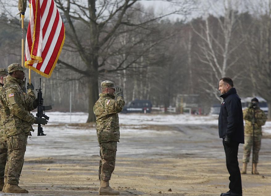 Polish President Andrzej Duda, right, stands in front of a saluting U.S. Army soldier during the opening of joint Polish and U.S. exercise on training fields in Zagan, Poland, Monday, Jan. 30, 2017. (AP Photo/Krzysztof Zatycki)