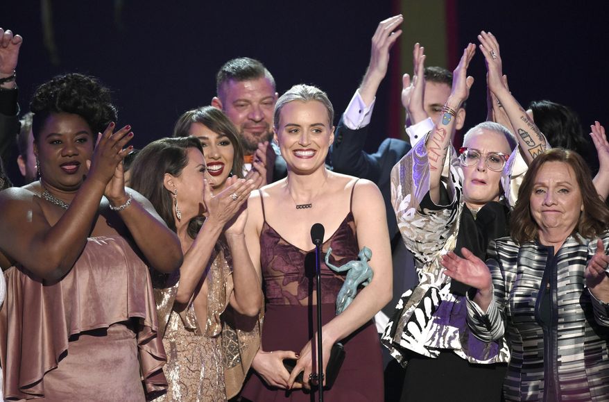 Taylor Schilling, center, and the cast of "Orange Is the New Black" accept the award for outstanding performance by an ensemble in a comedy series at the 23rd annual Screen Actors Guild Awards at the Shrine Auditorium & Expo Hall on Sunday, Jan. 29, 2017, in Los Angeles. (Photo by Chris Pizzello/Invision/AP)