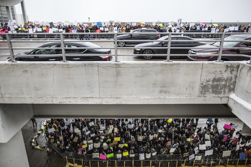 People gather during a protest against President Donald Trump's executive order banning travel to the United States by citizens of several countries Sunday, Jan. 29, 2017, at Detroit Metropolitan Airport. (Jeffrey M. Smith/The Times Herald via AP)