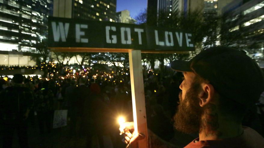 Paul Milano holds a sign reading "We Got Love," during a candlelight vigil at Thanksgiving Square in downtown Dallas, Monday, Jan. 30, 2017. People gathered to protest against President Donald Trump's executive order temporarily banning immigrants from seven Muslim-majority countries from entering the U.S. and suspending the nation’s refugee program. (AP Photo/LM Otero)
