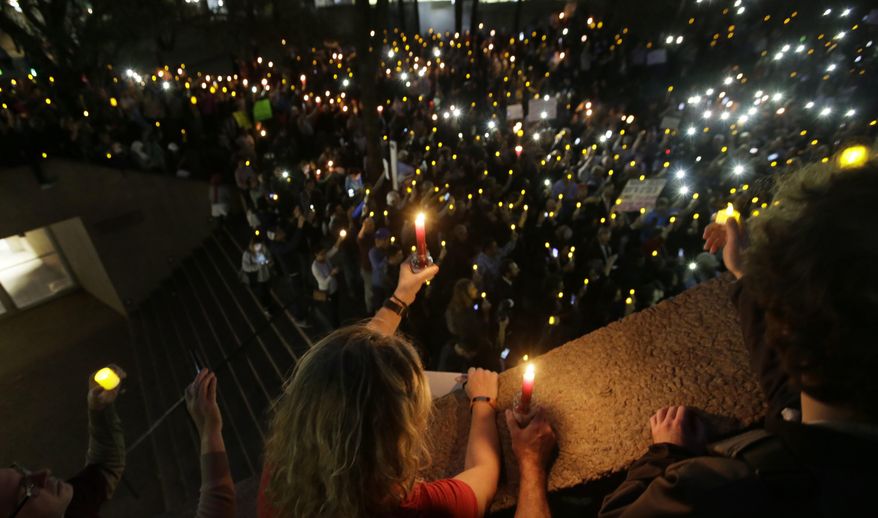 People hold candles during a vigil at Thanksgiving Square in downtown Dallas, Monday, Jan. 30, 2017. People gathered to protest against President Donald Trump's executive order temporarily banning immigrants from seven Muslim-majority countries from entering the U.S. and suspending the nation’s refugee program. (AP Photo/LM Otero)
