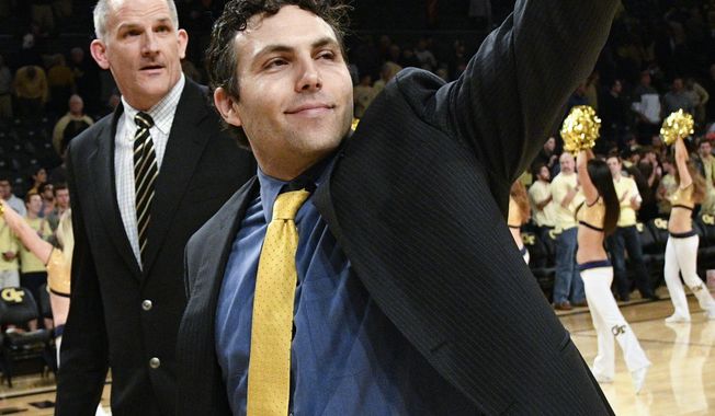 FILE - In this Jan. 25, 2017, file photo, Georgia Tech head coach Josh Pastner gestures to fans as he and assistant coach Eric Reveno walk off the court after their 78-56 win over Florida State in an NCAA basketball game in Atlanta. Pastner was expected to win no more than a couple of ACC games in his first season as Georgia Tech's coach, but the Yellow Jackets have surprisingly beaten two top 10 teams and another in the Top 25. (AP Photo/John Amis, File)