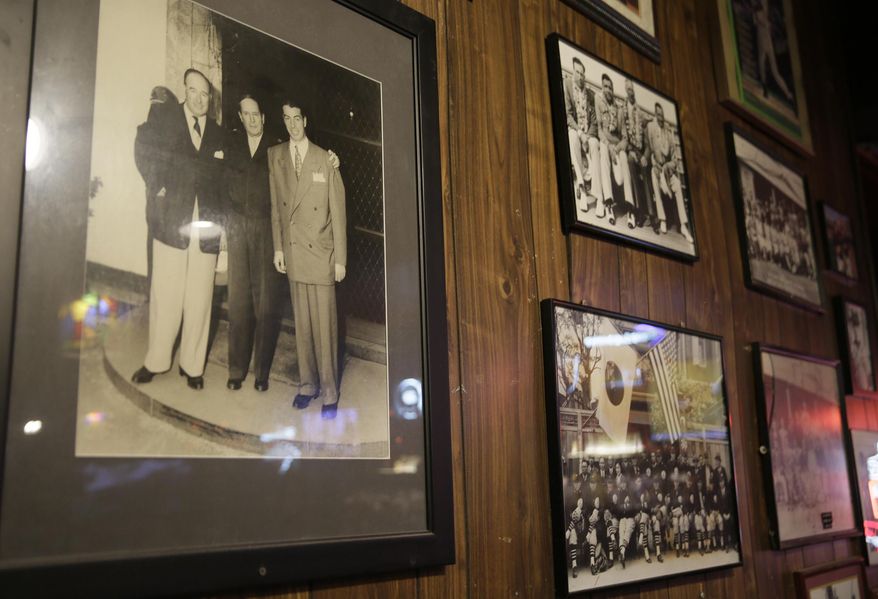 This photo taken Friday, Jan. 13, 2017, shows a photograph, left, taken in Japan of Lefty O'Doul, Gen. Douglas MacArthur and Joe DiMaggio hanging at Lefty O'Doul's restaurant and lounge in San Francisco. The historic baseball memorabilia and piano bar beloved by locals and tourists is set to close this week after its lease expires. Lefty O’Doul’s may return to downtown Union Square, but it's unclear who will be in charge as the bar's longtime operator and building owner are fighting over ownership. The establishment's final day is Wednesday, Feb. 1. (AP Photo/Eric Risberg)