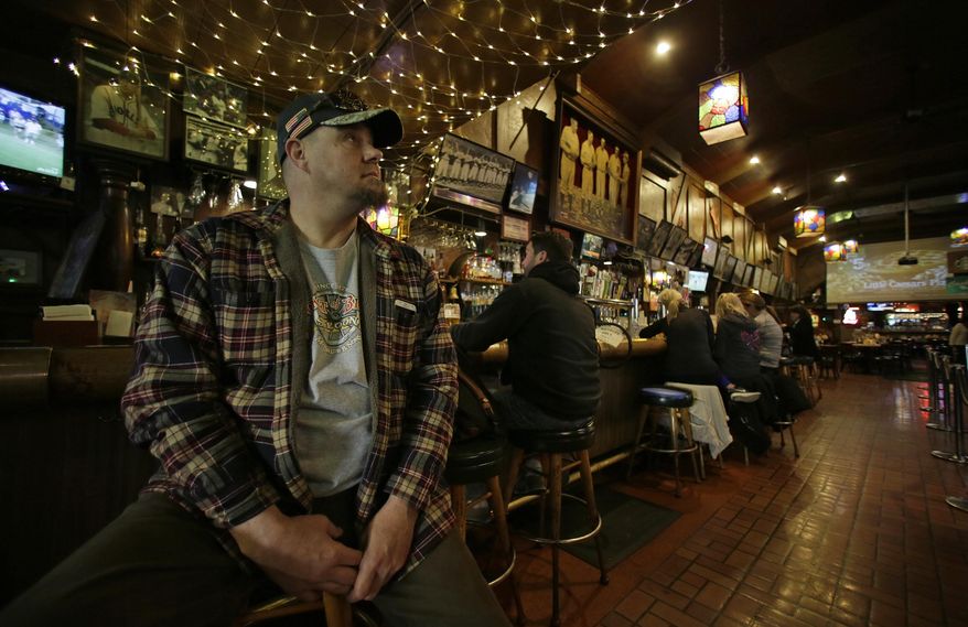 In this photo taken Friday, Jan. 13, 2017, Batu Plasch, of Martinez, Calif., takes a last look at old baseball photographs on the walls at Lefty O'Doul's restaurant and lounge in San Francisco. The historic baseball memorabilia and piano bar beloved by locals and tourists is set to close this week after its lease expires. Lefty O’Doul’s may return to downtown Union Square, but it's unclear who will be in charge as the bar's longtime operator and building owner are fighting over ownership. The establishment's final day is Wednesday, Feb. 1. (AP Photo/Eric Risberg)