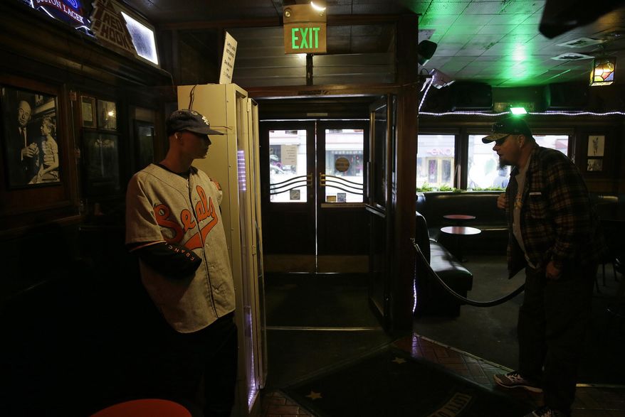 In this photo taken Friday, Jan. 13, 2017, Batu Plasch, of Martinez, Calif., takes a last look at a mannequin of Lefty O'Doul in the entryway of Lefty O'Doul's restaurant and lounge in San Francisco. The historic baseball memorabilia and piano bar beloved by locals and tourists is set to close this week after its lease expires. Lefty O’Doul’s may return to downtown Union Square, but it's unclear who will be in charge as the bar's longtime operator and building owner are fighting over ownership. The establishment's final day is Wednesday, Feb. 1. (AP Photo/Eric Risberg)