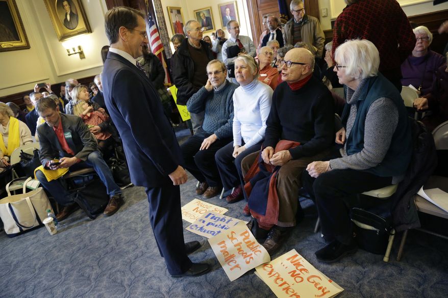 Frank Edelblut, left, Gov. Chris Sununu&#39;s nominee to lead the state&#39;s education department, speaks to people with signs opposing him, Tuesday, Jan. 31, 2017, before a public hearing at the Statehouse in Concord, N.H. (AP Photo/Elise Amendola)