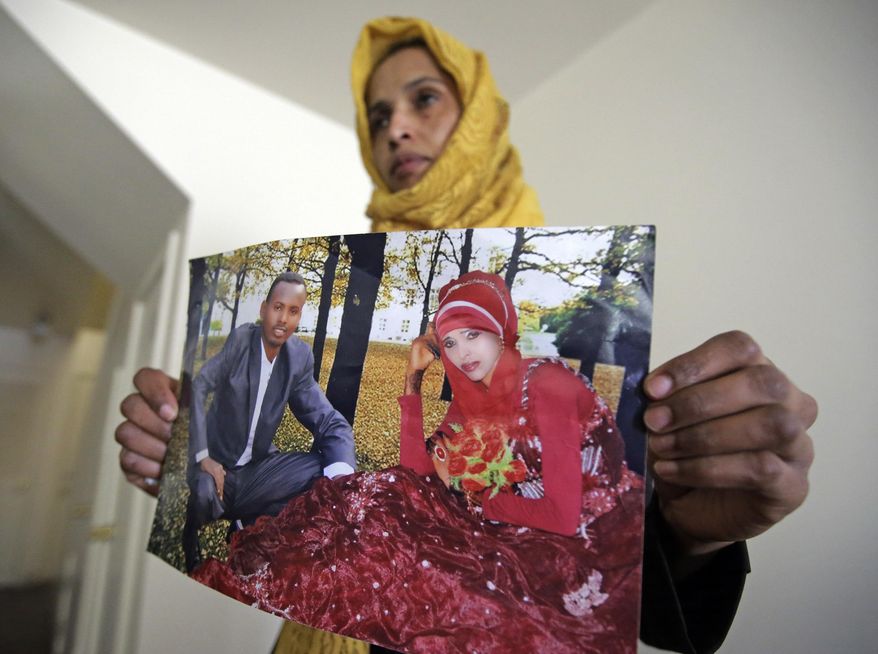 Somali refugee Nimo Hashi holds a photo of her husband Tuesday, Jan. 31, 2017, in Salt Lake City. Hashi bought a new kitchen table and couches for her Salt Lake City apartment in joyful anticipation of reuniting Friday with her husband for the first time in nearly three years. But he won't be arriving as planned to see her and the 2-year-old daughter he's never met. He is among hundreds of people stuck in limbo after President Donald Trump's executive order temporarily banned refugees and nearly all travelers from seven Muslim-majority countries, including Somalia. (AP Photo/Rick Bowmer)