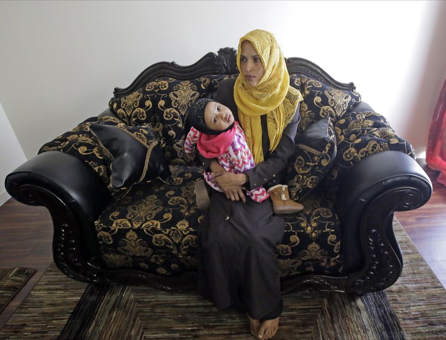 Somali refugee Nimo Hashi sits with her daughter Taslim at their home Tuesday, Jan. 31, 2017, in Salt Lake City. Hashi bought a new kitchen table and couches for her Salt Lake City apartment in joyful anticipation of reuniting Friday with her husband for the first time in nearly three years. But he won't be arriving as planned to see her and the 2-year-old daughter he's never met. He is among hundreds of people stuck in limbo after President Donald Trump's executive order temporarily banned refugees and nearly all travelers from seven Muslim-majority countries, including Somalia. (AP Photo/Rick Bowmer)