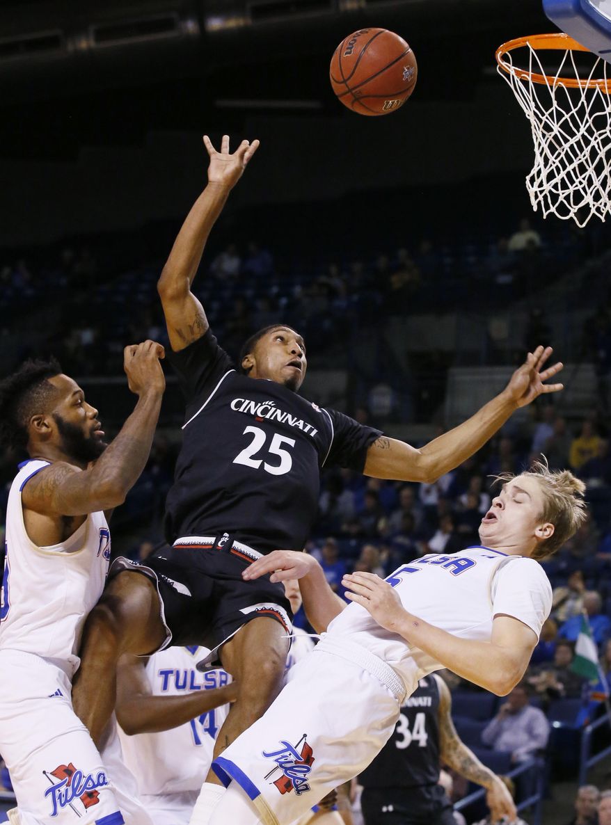 Cincinnati guard Kevin Johnson (25) loses the ball as he is fouled by Tulsa guard Lawson Korita, right, during the first half of an NCAA college basketball game in Tulsa, Okla., Wednesday, Feb. 1, 2017. Tulsa guard Jaleel Wheeler is at left. (AP Photo/Sue Ogrocki)