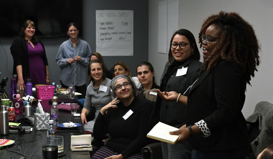 In this Jan. 25, 2017 photo, Shontel Lewis, right, introduces Vanessa Quintana, second from right, during an orientation meeting for Emerge Colorado on in Denver. Emerge is a national organization that recruits and trains Democratic women to run for local and state races - and then run again for a higher office. Emerge Executive director Jenny Willford stands at back left. (Helen H. Richardson/The Denver Post via AP)