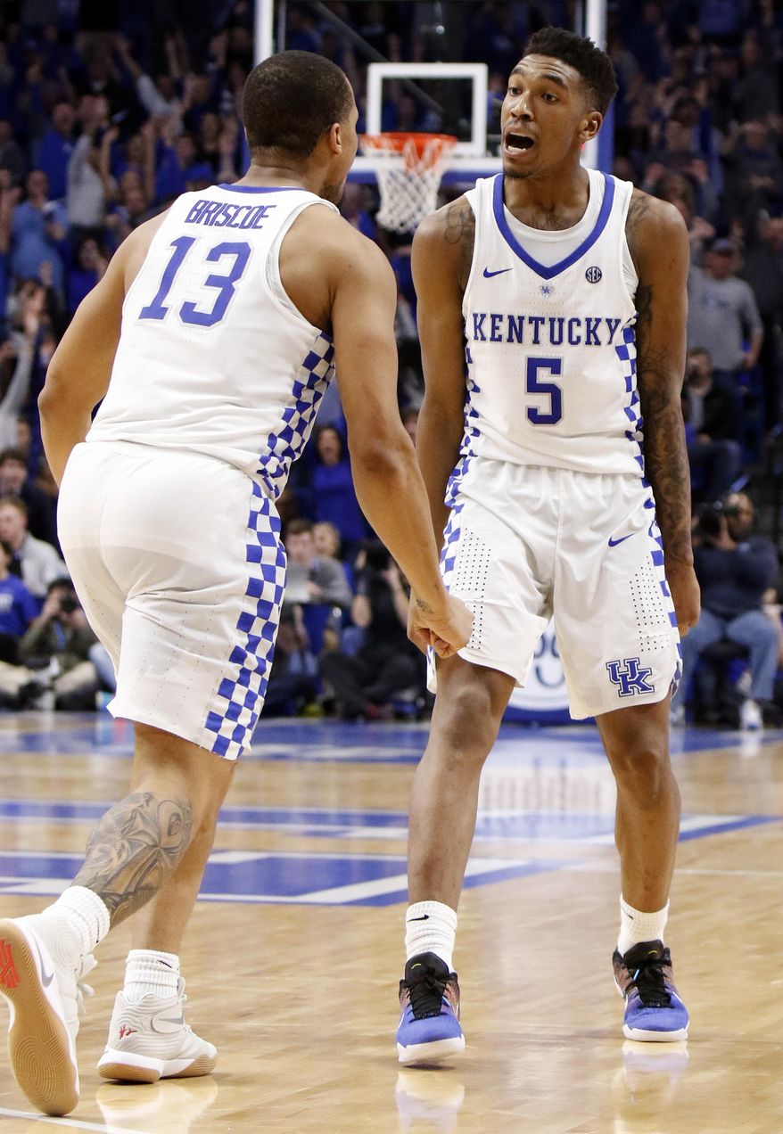 Kentucky's Malik Monk (5) and Isaiah Briscoe (13) celebrate during the overtime period of an NCAA college basketball game against Georgia, Tuesday, Jan. 31, 2017, in Lexington, Ky. Kentucky won 90-81 in overtime. (AP Photo/James Crisp)