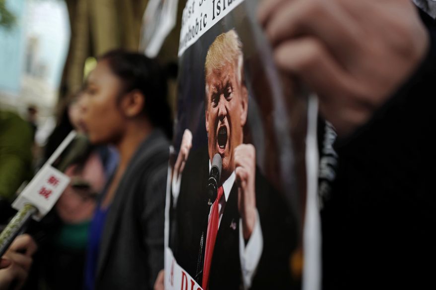 Activists chant slogans with placards during a protest against U.S. President Donald Trump's selective country travel ban outside of the U.S. Consulate in Hong Kong, Wednesday, Feb. 1, 2017. (AP Photo/Vincent Yu)