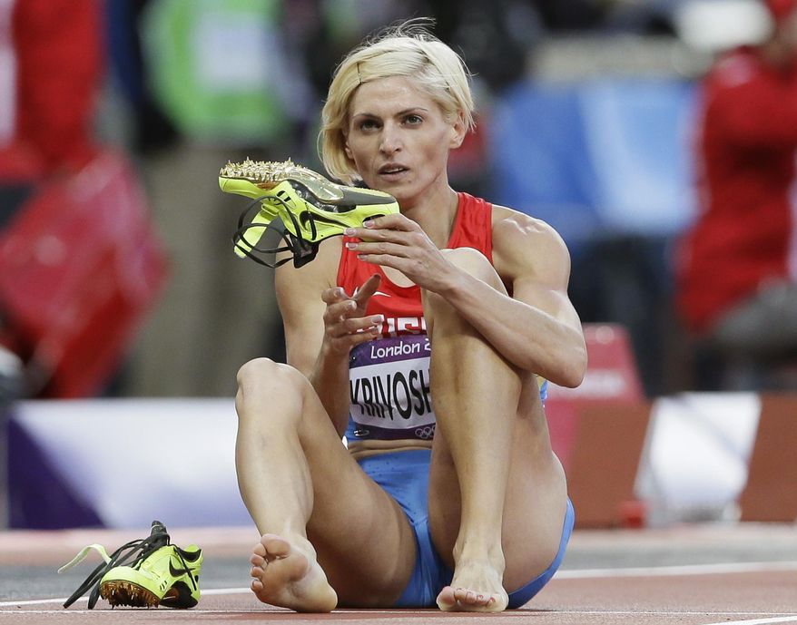 FILE - In this Aug. 4, 2012 file photo Russia's Antonina Krivoshapka takes off her shoes following a women's 400-meter semifinal during the athletics in the Olympic Stadium at the 2012 Summer Olympics, London. The IOC said Wednesday, Feb. 1, 2017 it has stripped Russia of an Olympic silver medal from the women's 4x400-meter relay at the 2012 London Games for doping. The IOC says Antonina Krivoshapka tested positive for the anabolic steroid turinabol in reanalysis of samples from the 2008 and 2012 Olympics. (AP Photo/Kirsty Wigglesworth, file)