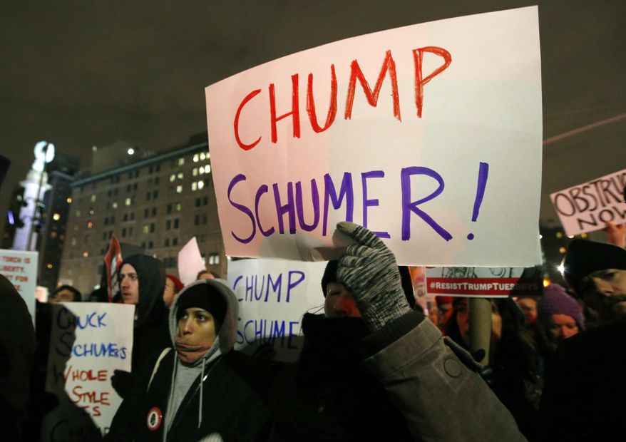 Demonstrators protesting Senate Minority leader Chuck Schumer hold signs at Brooklyn's Grand Army Plaza during a protest that was billed as the second in a series of "Resist Trump Tuesdays," on Tuesday, Jan. 31, 2017, in New York. Liberals are vowing to put pressure on Schumer to mount a vigorous opposition to the agenda of President Donald Trump. (AP Photo/Kathy Willens)