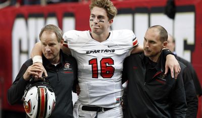 FILE -In this Dec. 9, 2016, file photo, Greater Atlanta Christian quarterback Davis Mills (16) is helped by staff as he leaves the field after he was injured in the first half against Cedar Grove during the Class AAA state championship high school football game at the Georgia Dome in Atlanta. Stanford does not allow freshman to enroll early so Mills is likely looking toward a quarterback competition with K.J. Costello in 2018.  (Jason Getz/Atlanta Journal-Constitution via AP, File)