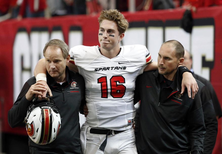 FILE -In this Dec. 9, 2016, file photo, Greater Atlanta Christian quarterback Davis Mills (16) is helped by staff as he leaves the field after he was injured in the first half against Cedar Grove during the Class AAA state championship high school football game at the Georgia Dome in Atlanta. Stanford does not allow freshman to enroll early so Mills is likely looking toward a quarterback competition with K.J. Costello in 2018. (Jason Getz/Atlanta Journal-Constitution via AP, File)