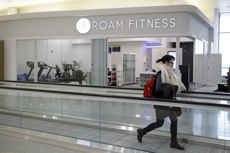 In this Jan. 30, 2017 photo, a traveler walks past the soon-to-be-open ROAM Fitness gym at Baltimore-Washington International Thurgood Marshall Airport in Linthicum, Md. Working out while waiting for your flight will soon be an option at BWI, where the only gym at a U.S. airport past security will open this week, with plans for 20 more at airports by 2020. (AP Photo/Patrick Semansky)