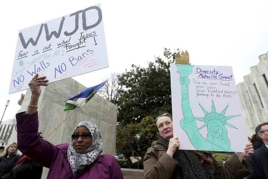 Asli Ali, 39, of Woodburn, left, and Dana Bliss, 56, of Salem, attend an immigrant and refugee rights rally, in response to President Trump's ban on people entering the United States from seven Muslim-majority countries, at the Oregon State Capitol in Salem, Ore., on Wednesday, Feb. 1, 2017. Ali is an Arabic and Somali interpreter for local school districts and both women work to help resettle refugees in the Willamette Valley. (Anna Reed /Statesman-Journal via AP)