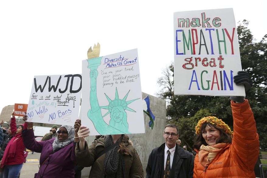 Asli Ali, 39, of Woodburn, from left, Dana Bliss, 56, of Salem, and Kristen Wilson, 58, of Salem, attend an immigrant and refugee rights rally, in response to President Trump's ban on people entering the United States from seven Muslim-majority countries, at the Oregon State Capitol in Salem on Wednesday, Feb. 1, 2017. Ali is an Arabic and Somali interpreter for local school districts and all three women work to help resettle refugees in the Willamette Valley. (Anna Reed /Statesman-Journal via AP)