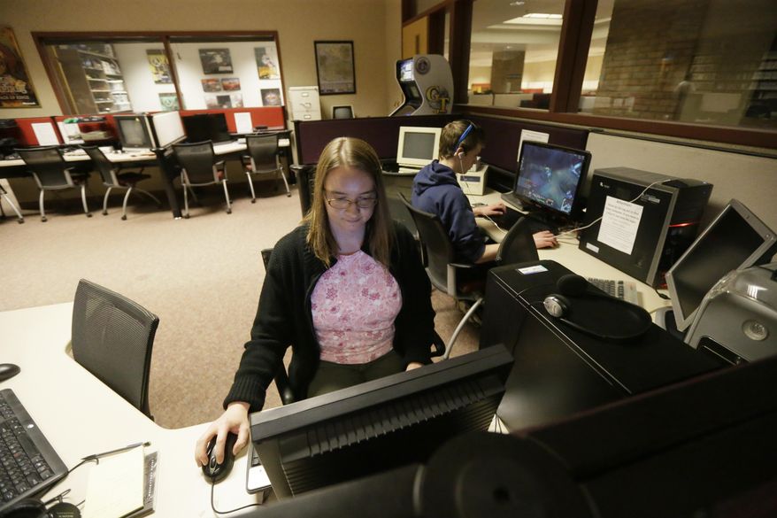 In this May 20, 2016, Valerie Waldron, manager of the Computer and Video Game Archive, works on a terminal at the University of Michigan in Ann Arbor, Mich. The university's archive features over 7,000 titles - everything from time-honored favorites such as "Pac-Man" and "Frogger" to newer fare, including "Call of Duty" and "Halo" - on dozens of gaming systems. And unlike some other video game archives out there, students and members of the public alike are permitted to visit and play any game available, whether for research or just to relax. (AP Photo/Carlos Osorio)