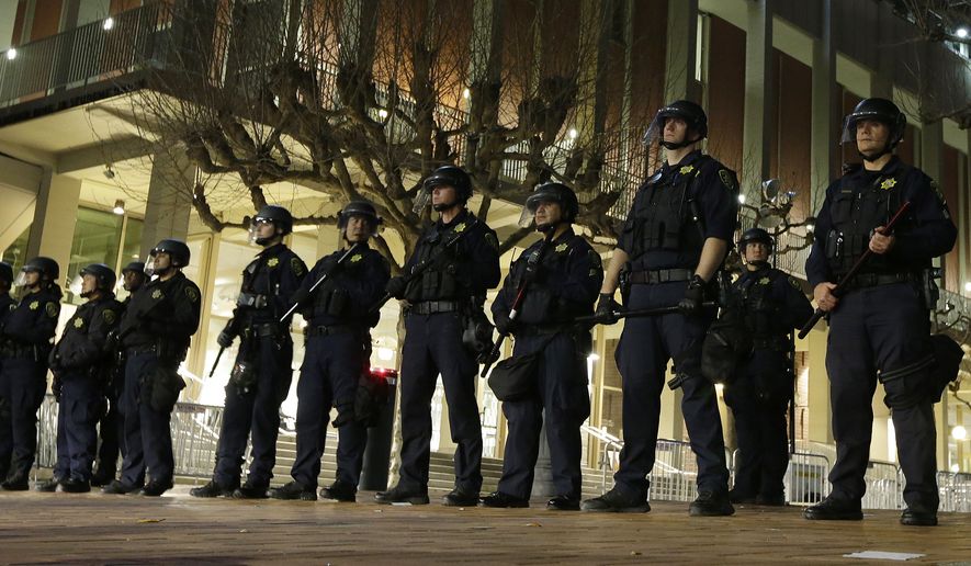 University of California at Berkeley police guard the building where Breitbart News editor Milo Yiannopoulos was to speak Wednesday, Feb. 1, 2017, in Berkeley, Calif. A small group of people with their faces covered broke windows, hurled fireworks at police officers and threw smoke bombs, prompting UC Berkeley officials to cancel Yiannopoulos&#39;s talk Wednesday evening. (AP Photo/Ben Margot)