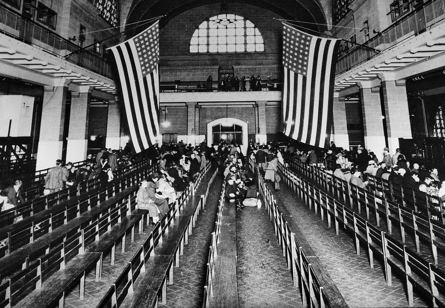 FILE - This 1924 file photo shows the registry room at Ellis Island in New York harbor, a gateway to America for millions of immigrants. The American self-image is forever intertwined with the melting pot _ a nation that embraces the world’s wretched refuse, a nation built by immigrants. But America’s immigration history is complicated. (AP Photo/File)