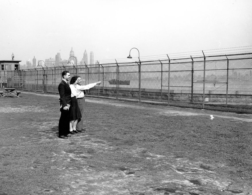 FILE - In this April 7, 1949 file photo, immigrants look at the view from Ellis Island in New York Harbor. The Manhattan skyline is behind them. The American self-image is forever intertwined with the melting pot _ a nation that embraces the world’s wretched refuse, a nation built by immigrants. But America’s immigration history is complicated. (AP Photo/Fitzsimmons, File)