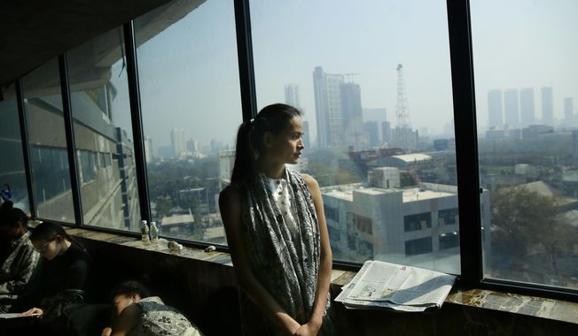 In this  Jan 30, 2017 photo, Anjali Lama, a transgender model from Nepal, looks out of a window of a hotel during a trial event for Lakme Fashion week in Mumbai, India. Growing up as the fifth son in a poor farming family in rural Nepal the dream to be a fashion model came late in life. First came a long, painful struggle to accept that he felt deeply female. It was a chance encounter with a group of transgender women that turned Lama's life around by putting her in touch with the Blue Diamond Society, an advocacy group for Nepal's LGBT community. In 2005 she came out to her friends and family as a transgender woman. (AP Photo/Rafiq Maqbool)