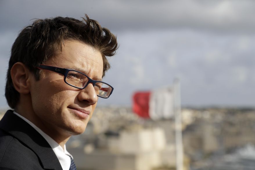 Alex Mangion listens to a journalist's question during an interview with the Associated Press, in Valletta, Wednesday, Feb. 1, 2017. Lithe and dapper in a navy-blue suit as he gazed at this capital city's storied Grand Harbor, Alex Mangion proudly described becoming Malta's first transgender politician, winning a local office on the conservative Nationalists' ticket in a country that until just a few years ago had been a last bastion in Western Europe of social norms largely dictated by the Catholic church. (AP Photo/Gregorio Borgia)