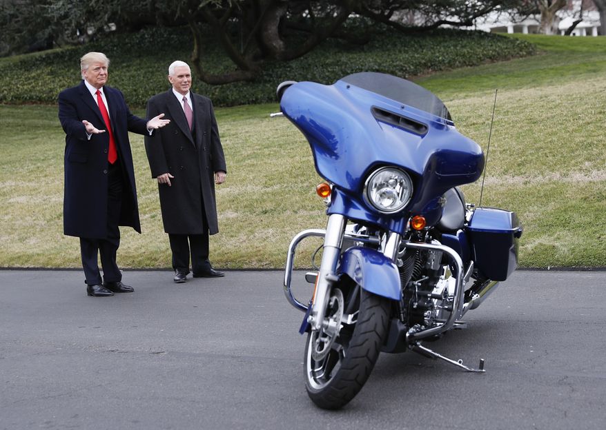 President Donald Trump and Vice President Mike Pence stop to admire a Harley Davidson motorcycle parked on the South Lawn of the White House in Washington, Thursday, Feb. 2, 2017, as he welcomed Harley Davidson executives and union representatives. (AP Photo/Pablo Martinez Monsivais)