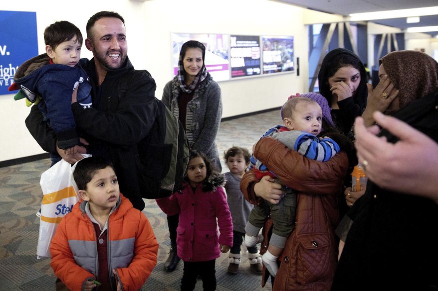 Mohammad Mobin smiles while holding his nephew, Bashir Ahmad Rahimi, after greeting his sister's family that arrived from Afghanistan Wednesday, Feb 1, 2017, in Omaha, Neb. The family became the last refugees to land in Omaha before President Donald Trump's executive order freezing all refugee resettlements took full effect. (Megan Farmer/Omaha World-Herald via AP)